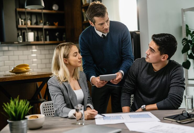 imgi_11_rear-estate-agent-young-couple-going-through-blueprints-using-digital-tablet-meeting_637285-3873